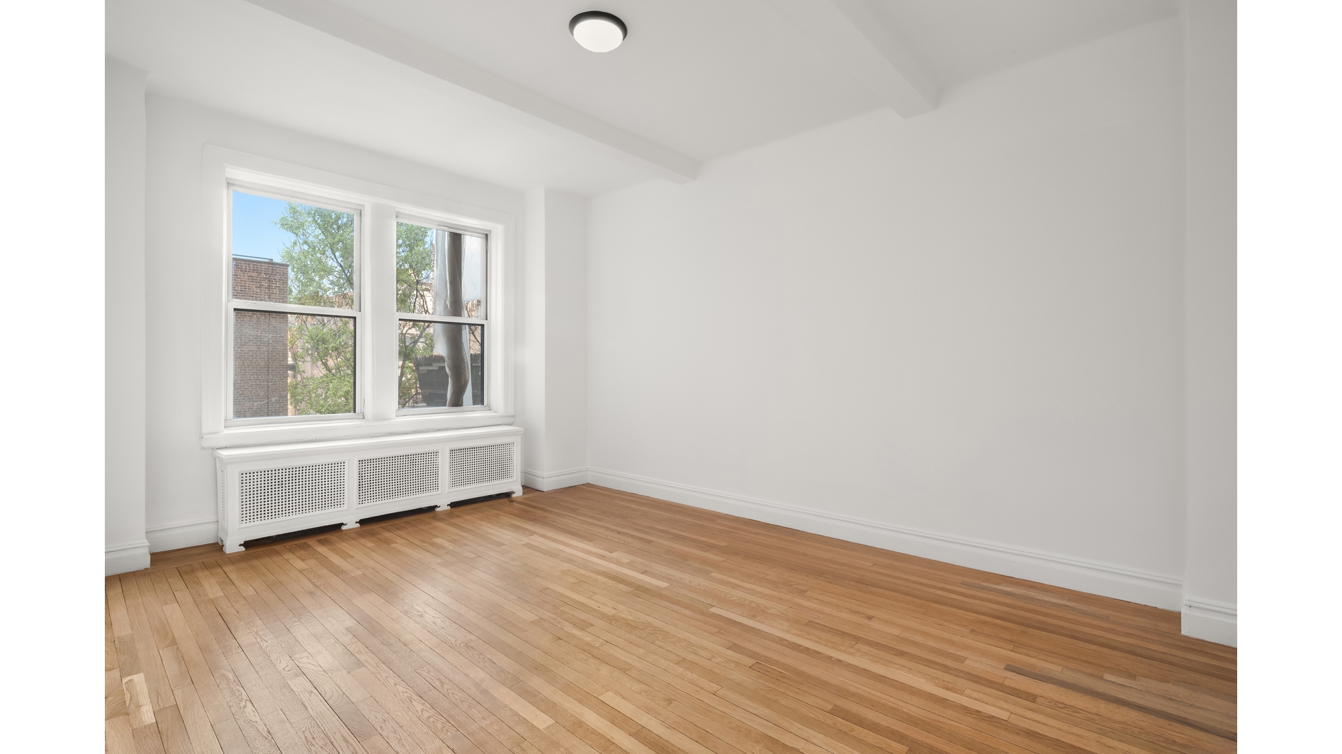 340 Riverside Drive, Unit 6D Manhattan, NY 10025 - Photo 12 of 26 an empty room with wooden floor and windows