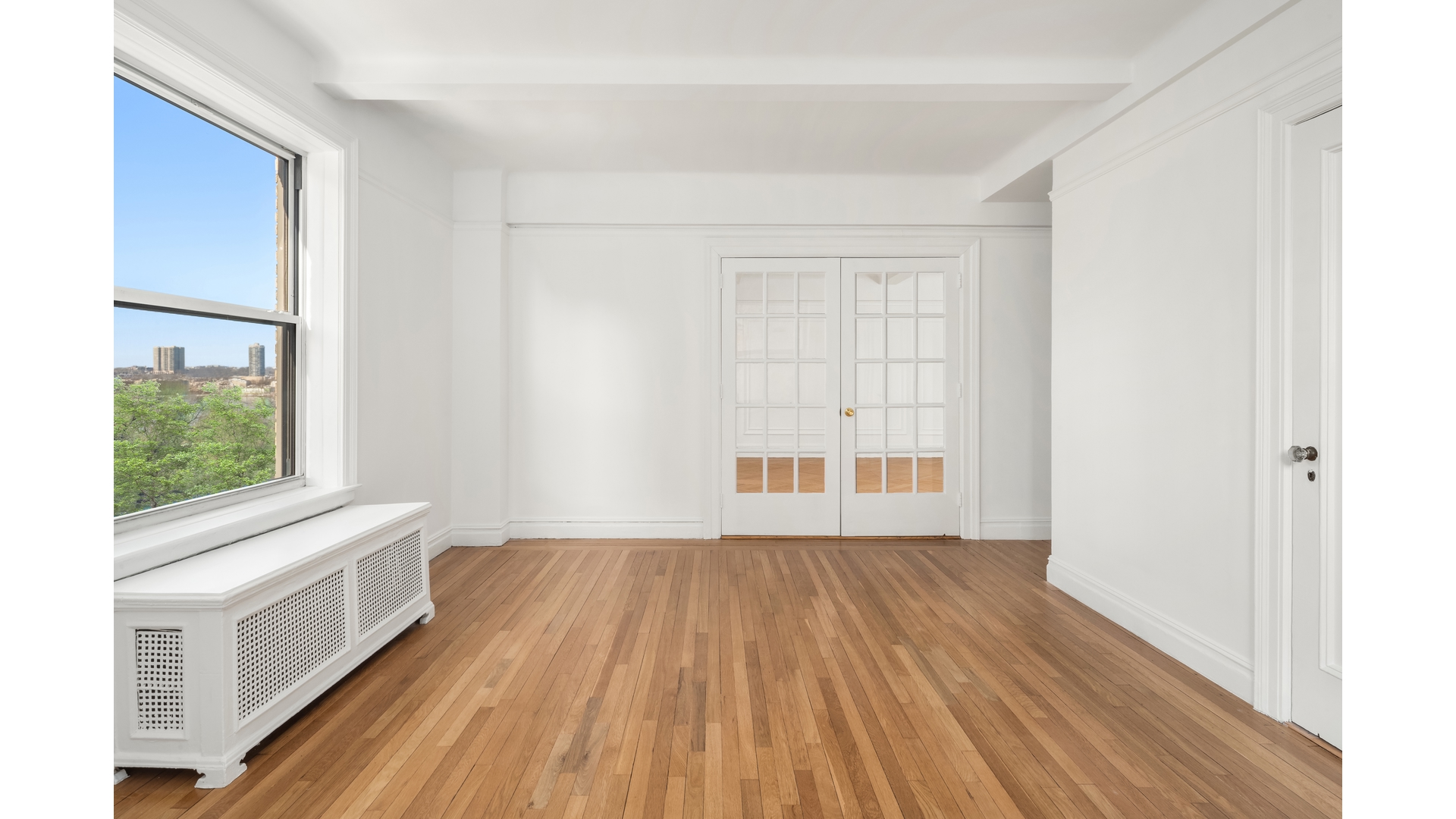 340 Riverside Drive, Unit 6D Manhattan, NY 10025 - Photo 19 of 26 a view of an empty room with a window and wooden floor