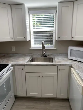 a kitchen with white cabinets and a sink