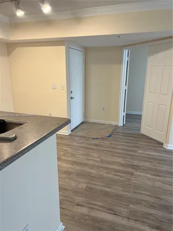 a view of a room with wooden floor and cabinets