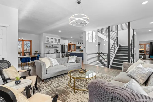 a living room with furniture kitchen view and a large window