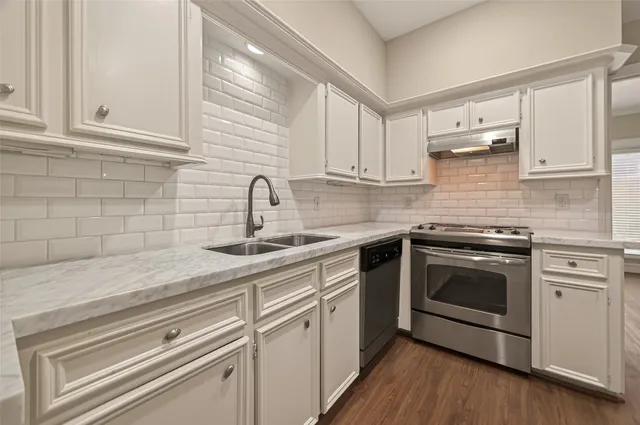 a kitchen with white cabinets stainless steel appliances and sink