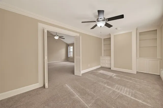 an empty room and chandelier fan