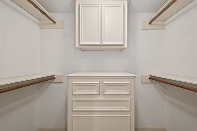 a view of walk in closet with empty racks