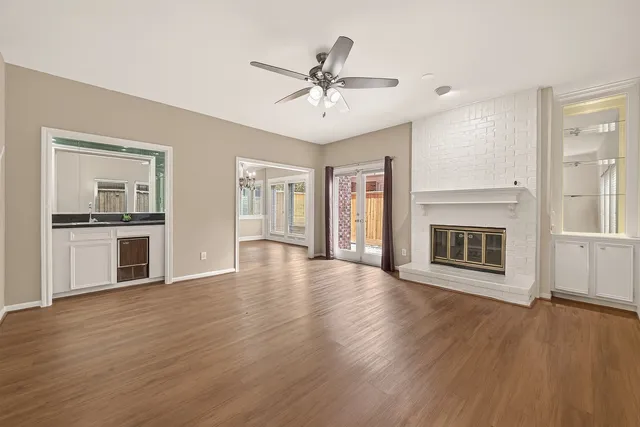 a view of an empty room with window and wooden floor