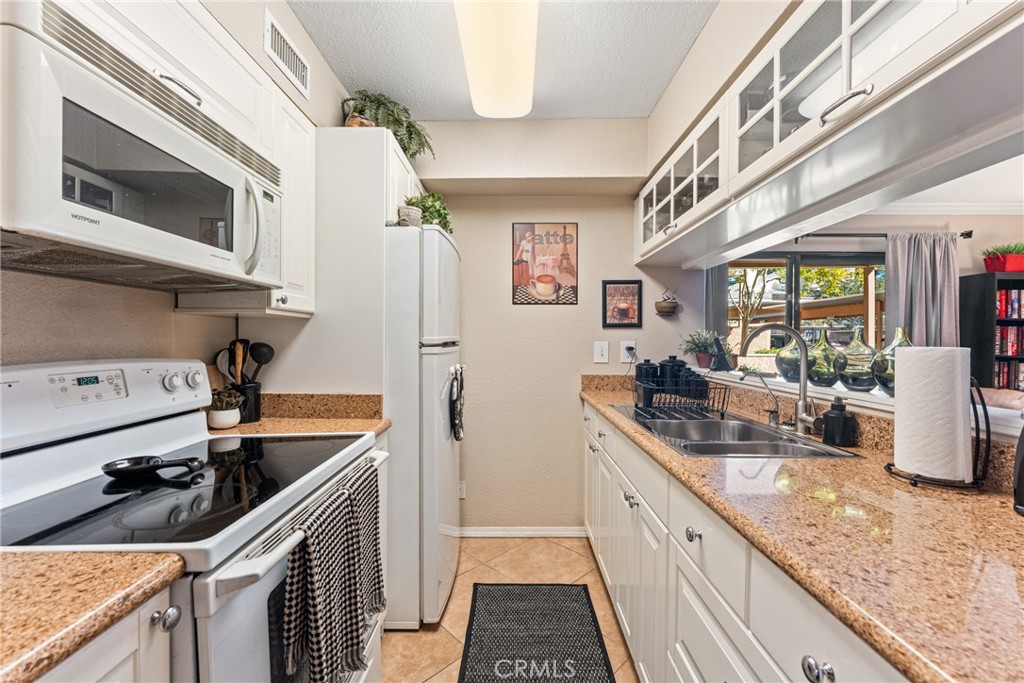 10655 Lemon Avenue Rancho Cucamonga, CA 91737 - Photo 8 of 32 a kitchen with stainless steel appliances granite countertop a sink stove and refrigerator