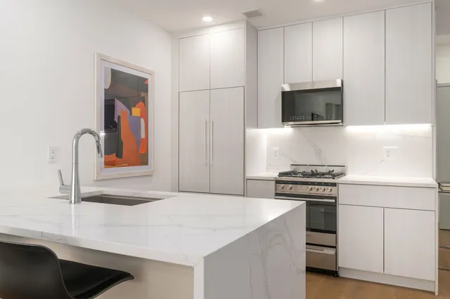 a kitchen with stainless steel appliances granite countertop a sink and a stove