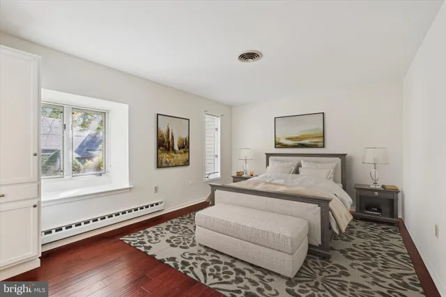 a bedroom with a bed and a painting on the wall