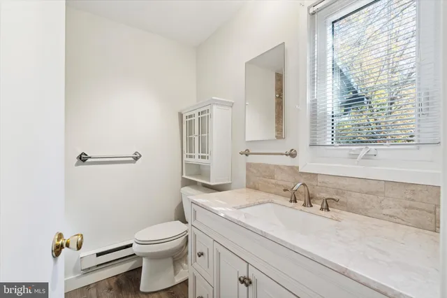 a bathroom with a granite countertop sink toilet a mirror and shower