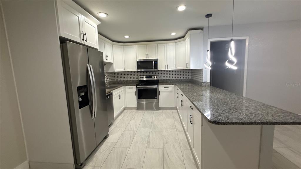 8106 Wichita Way Tampa, FL 33619 - Photo 7 of 21 a kitchen with stainless steel appliances granite countertop a refrigerator and a sink