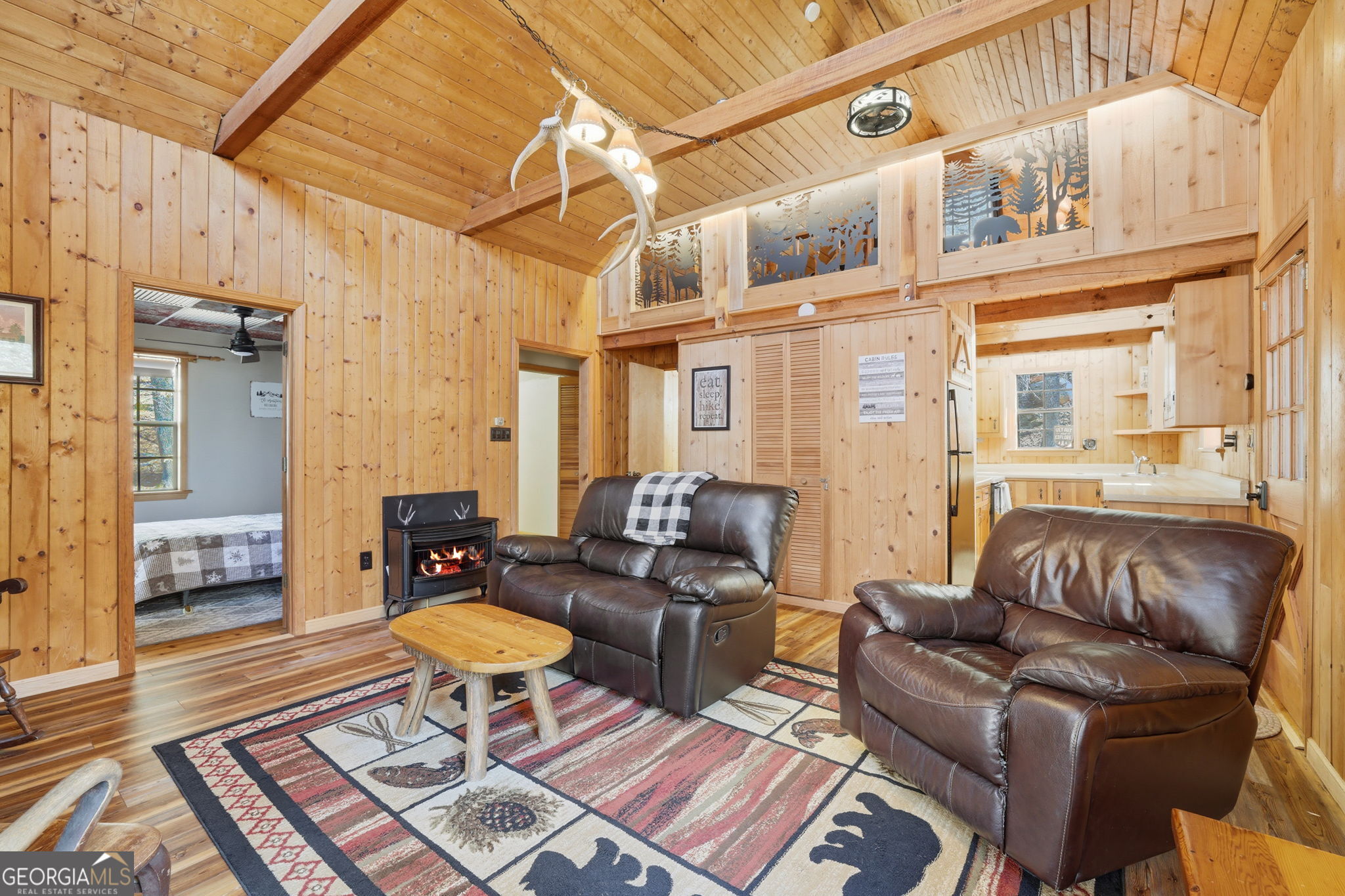 355 Henslee Hollow Lane Rabun Gap, GA 30568 - Photo 5 of 47 a living room with furniture a rug and a chandelier