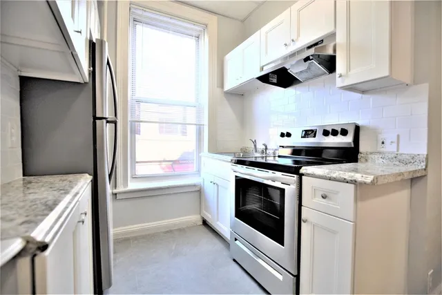 a kitchen with stainless steel appliances granite countertop a sink and a stove