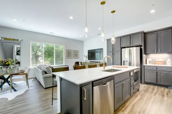 a kitchen that has a lot of cabinets a sink and a stove in it