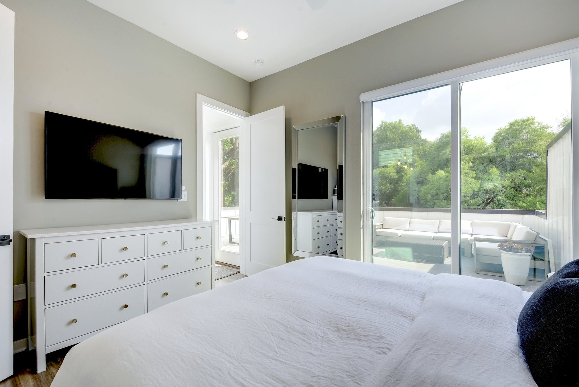 2804 South 1st Street, Unit 3103 Austin, TX 78704 - Photo 13 of 23 a bedroom with a large bed and a flat tv screen next to a window