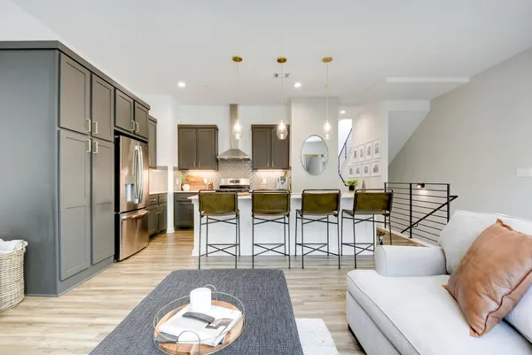 a living room with lots of furniture and kitchen view