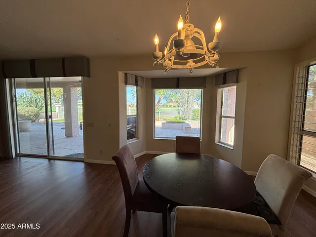 a view of a dining room with furniture a chandelier and wooden floor