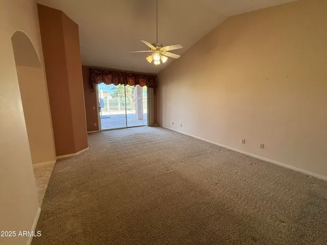 a view of a livingroom with a ceiling fan and window
