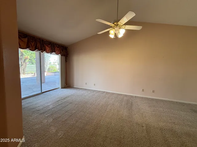 an empty room with windows and ceiling fan