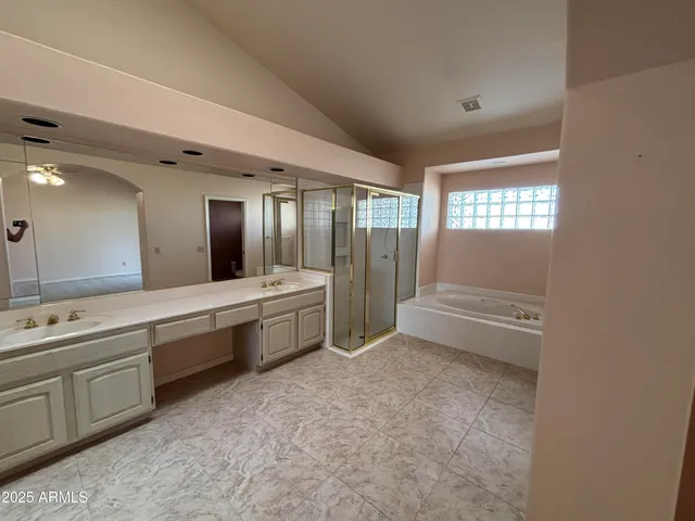 a large bathroom with a tub sink shower and mirror
