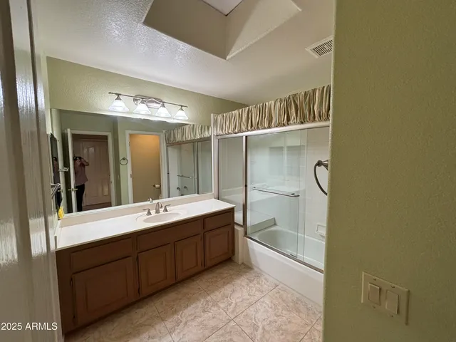 a bathroom with a double vanity sink and mirror with shower