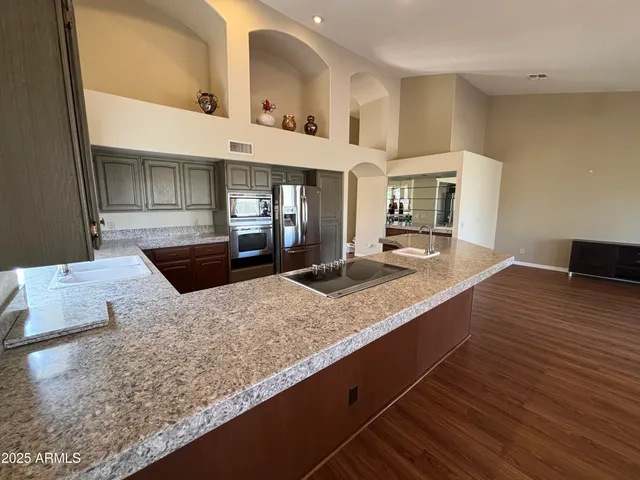 a kitchen with stainless steel appliances granite countertop a sink and a stove