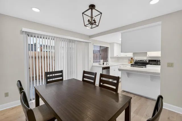 a kitchen with a dining table chairs and refrigerator