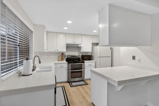 a kitchen with a stove a sink and a refrigerator