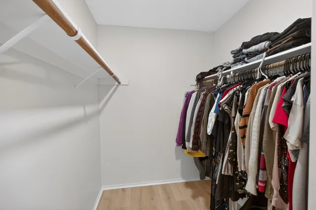 a view of walk in closet with clothes and shoes