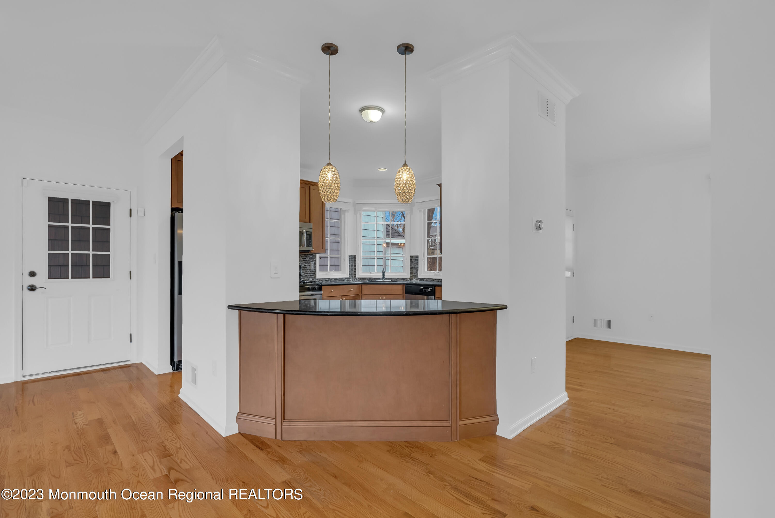 16 Mariners Bend Brielle, NJ 08730 - Photo 21 of 66 a view of a kitchen with kitchen island a sink wooden floor and a glass door
