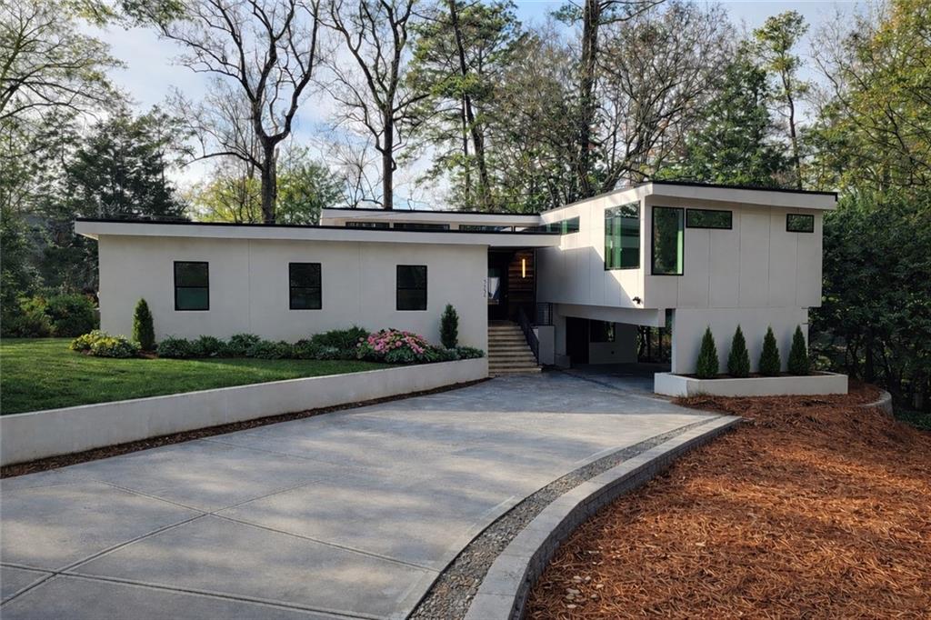 a front view of house with yard and trees in the background