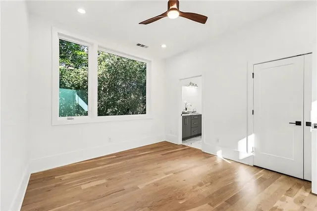 an empty room with mirror and windows