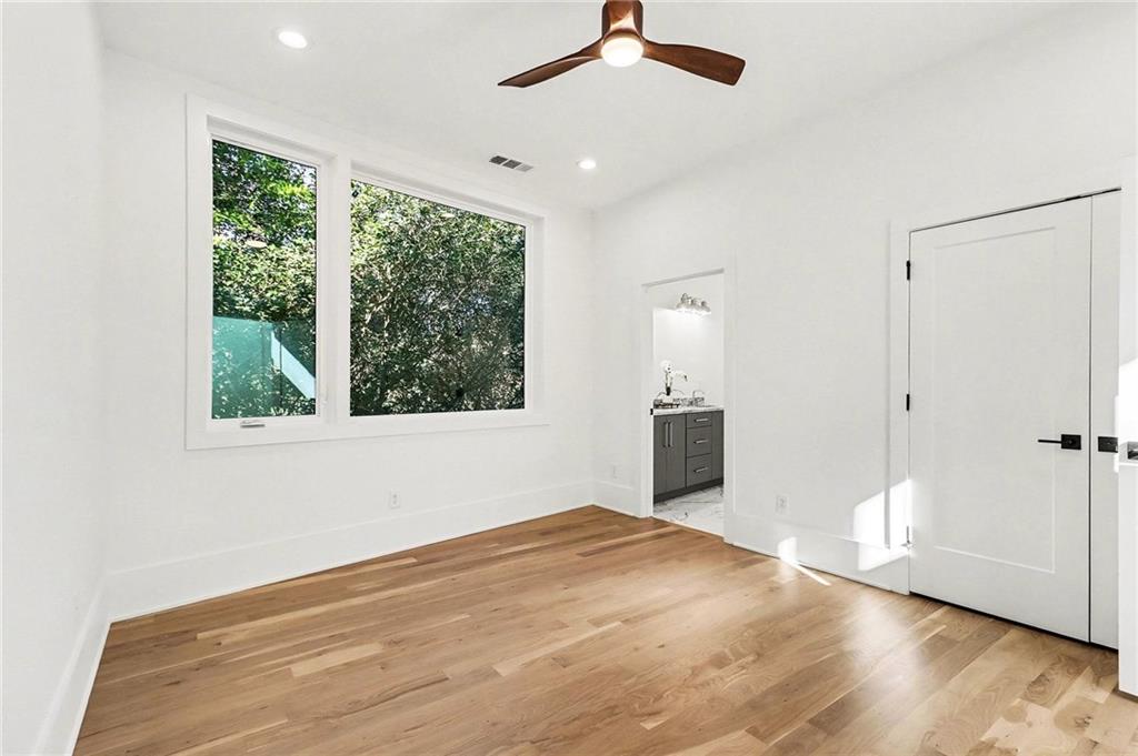 3134 West Roxboro Road Northeast Atlanta, GA 30324 - Photo 34 of 62 an empty room with wooden floor fan and windows