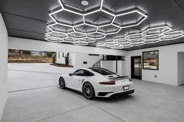 a dining room with wooden floor a chandelier a wooden table and chairs
