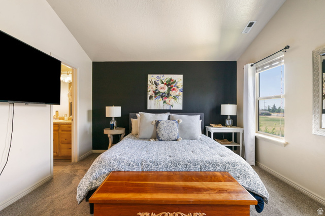 1393 West 150 North Springville, UT 84663 - Photo 4 of 31 Carpeted room featuring a dark accent wall, a large window, and an en-suite bathroom visible through an open doorway