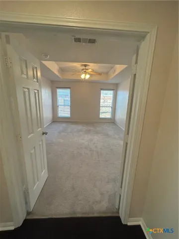 an empty room with windows and fan