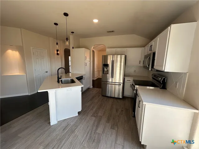a kitchen with a refrigerator and a stove