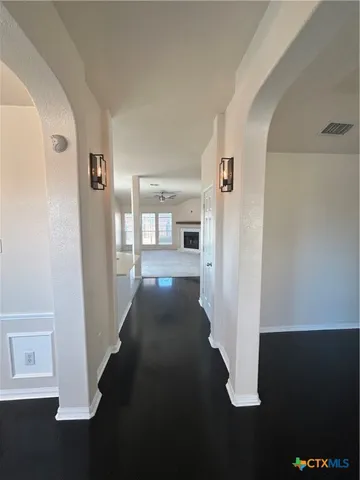 a view of a hallway with wooden floor and cabinet