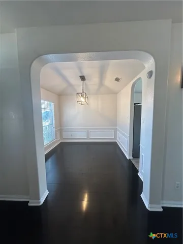 a view of empty room with window and wooden floor
