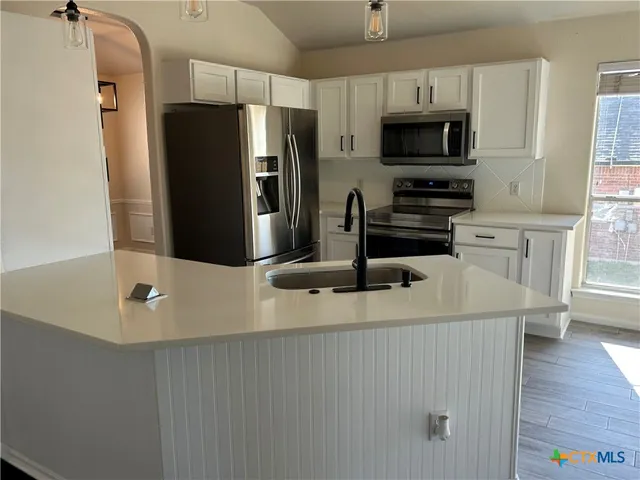 a kitchen with stainless steel appliances a refrigerator a stove a microwave and cabinets