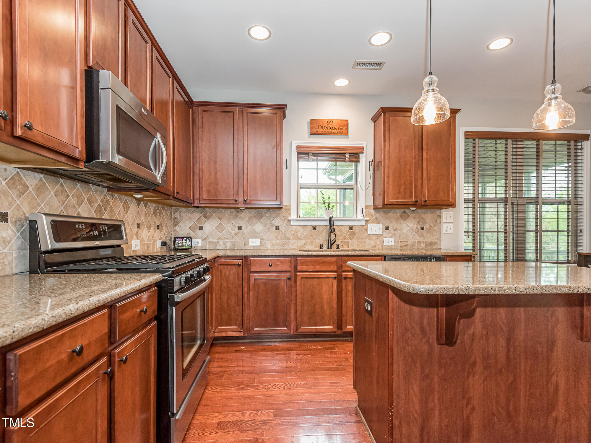 111 Gathering Place Durham, NC 27713 - Photo 15 of 44 a kitchen with stainless steel appliances granite countertop wooden cabinets a sink and a stove