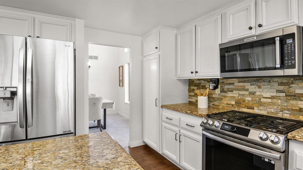 354 Lustrosos Street Oceanside, CA 92057 - Photo 24 of 75 a kitchen with stainless steel appliances granite countertop a stove a refrigerator and a microwave