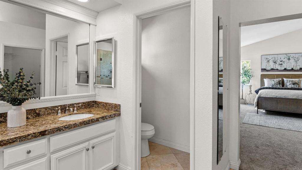 354 Lustrosos Street Oceanside, CA 92057 - Photo 37 of 75 a en suite bathroom with a granite countertop sink and a mirror