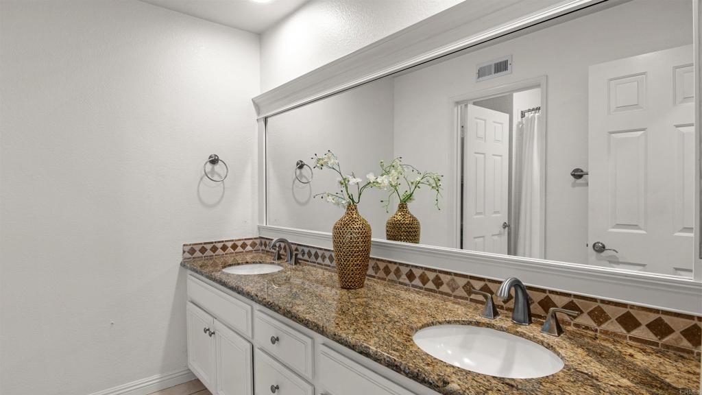 354 Lustrosos Street Oceanside, CA 92057 - Photo 40 of 75 a bathroom with a granite countertop sink and a mirror