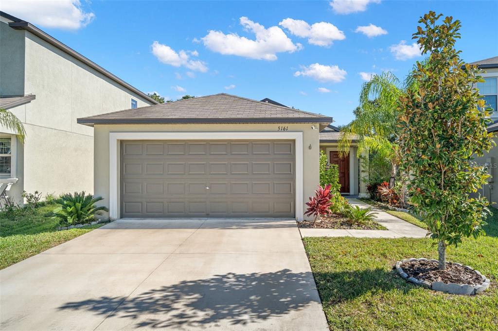 a front view of a house with a yard and garage