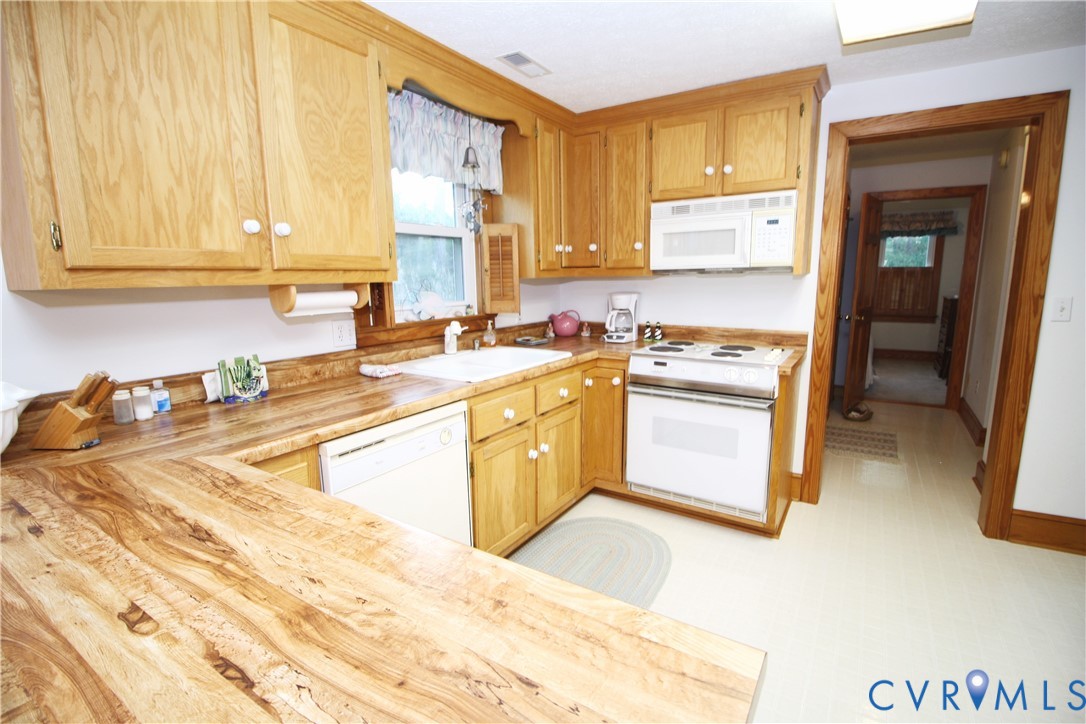 68 Springtide Lane Port Haywood, VA 23138 - Photo 15 of 33 a kitchen with a stove a sink and a refrigerator