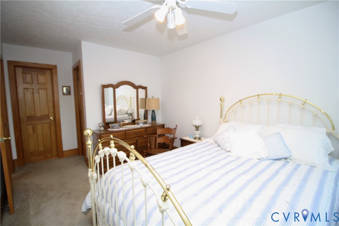 68 Springtide Lane Port Haywood, VA 23138 - Photo 26 of 33 a bedroom with a bed and a chandelier