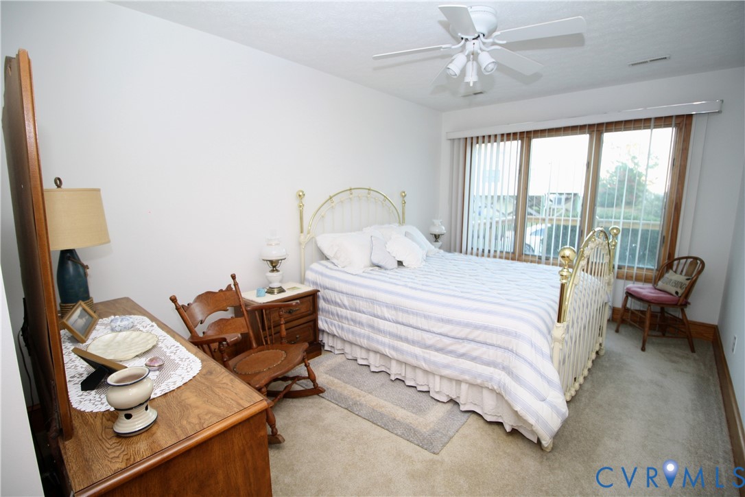68 Springtide Lane Port Haywood, VA 23138 - Photo 27 of 33 a bedroom with a bed and a chandelier