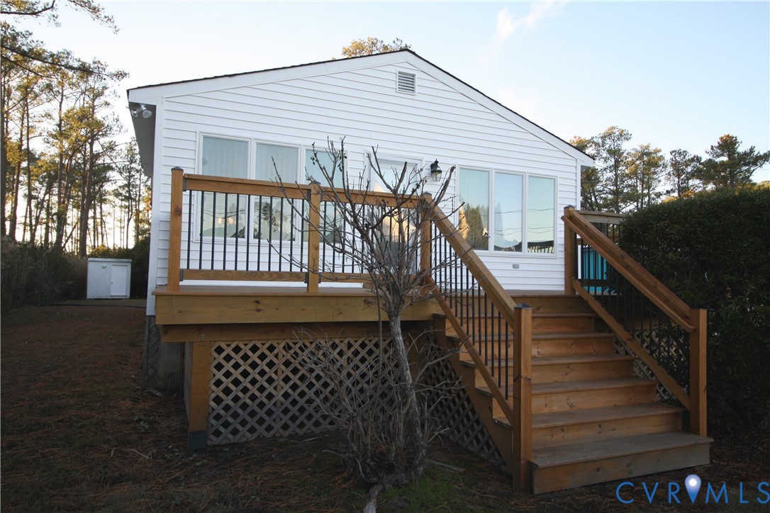 68 Springtide Lane Port Haywood, VA 23138 - Photo 4 of 33 a front view of a house with wooden stairs and a bench