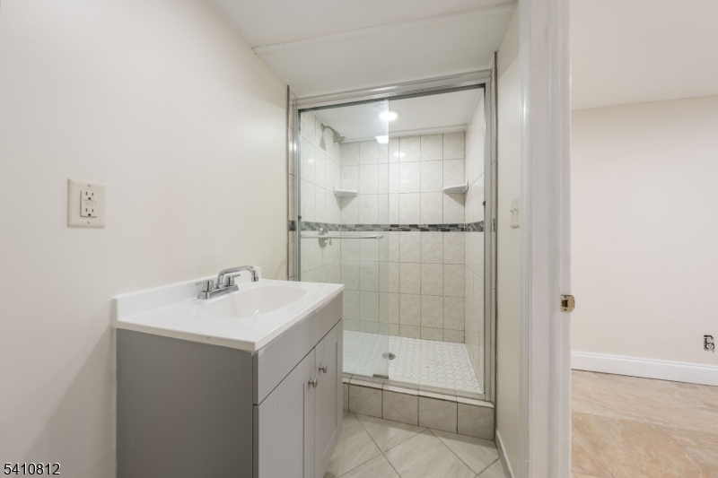 985 Arnet Avenue Union, NJ 07083 - Photo 14 of 26 a bathroom with a shower sink vanity and mirror