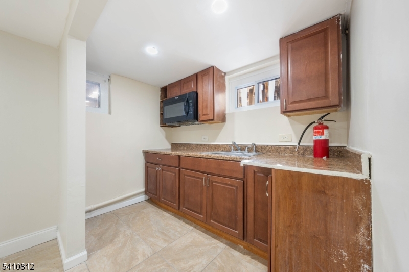 985 Arnet Avenue Union, NJ 07083 - Photo 16 of 26 a kitchen with granite countertop a sink and a stove top oven